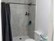 A remodeled bathroom featuring gray tiled walls, a hexagon-tiled shower floor, and a modern shower head fixture at 3154 Stonecastle Rd, Orlando, FL 32822