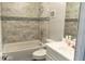 Bathroom featuring white and grey wall tile, a shower-tub, and a white single-sink vanity at 3154 Stonecastle Rd, Orlando, FL 32822