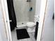 A remodeled bathroom featuring gray tiled walls, a hexagon-tiled shower floor, and a modern shower head fixture at 3154 Stonecastle Rd, Orlando, FL 32822