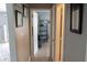 Hallway with wood floors leads to a bright room with beach-themed decor and black metal shelving at 3154 Stonecastle Rd, Orlando, FL 32822