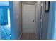 Hallway view of the front door and living room; the hallway leads to a white bedroom door on the right at 3154 Stonecastle Rd, Orlando, FL 32822