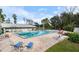 Community swimming pool with lounge chairs, umbrella and picnic table and surrounded by grass at 3154 Stonecastle Rd, Orlando, FL 32822