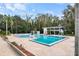 Community swimming pools with lounge area, next to pool house and surrounded by mature trees at 3154 Stonecastle Rd, Orlando, FL 32822