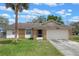 Charming single-story home featuring a stone facade, one-car garage, and a well-maintained front lawn with palm tree at 3199 Tobago Ct, Apopka, FL 32703