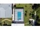 Aerial view of a pool with a screened enclosure, lush landscaping, and surrounding greenery at 4170 Packard Ave, St Cloud, FL 34772