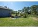 Backyard with a small pond, green grass, and view of trees at 4170 Packard Ave, St Cloud, FL 34772