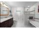 Bright bathroom featuring a glass-enclosed shower, soaking tub, and marble countertop vanity at 4170 Packard Ave, St Cloud, FL 34772