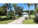 Long driveway with partial home view surrounded by mature trees and green grass at 4170 Packard Ave, St Cloud, FL 34772
