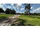 Long gravel driveway leading to the detached garage on a sunny day at 4170 Packard Ave, St Cloud, FL 34772