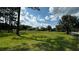 Wide shot of the house and detached garage surrounded by green grass at 4170 Packard Ave, St Cloud, FL 34772