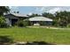 Exterior of a home with a detached garage and a spacious lawn at 4170 Packard Ave, St Cloud, FL 34772