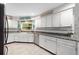 Bright kitchen featuring white cabinets, granite counters, stainless steel appliances, and tiled flooring at 4170 Packard Ave, St Cloud, FL 34772