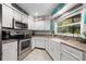 Bright kitchen with white cabinets, stainless appliances, and a farmhouse style sink at 4170 Packard Ave, St Cloud, FL 34772