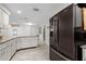 Bright, white kitchen featuring stainless steel fridge and granite countertops at 4170 Packard Ave, St Cloud, FL 34772