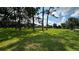 A large grassy yard with mature trees and the home in the background at 4170 Packard Ave, St Cloud, FL 34772