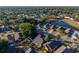 Aerial view featuring a house in a residential area with a pond and lush green trees surrounding the neighborhood at 4232 Sandhurst Dr, Orlando, FL 32817