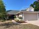 Charming home with a two-car garage, lush landscaping, and a walkway leading to the front door at 4232 Sandhurst Dr, Orlando, FL 32817