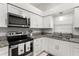 Bright kitchen featuring granite countertops, stainless steel appliances, and white cabinetry at 4232 Sandhurst Dr, Orlando, FL 32817