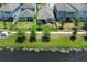 Aerial view showcasing a pond, green lawns, black metal fences, and surrounding homes in a residential area at 4548 Dulwik Pl, Sanford, FL 32771