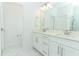 Bright bathroom featuring double vanity with white cabinetry, marble floors, and a large mirror at 4548 Dulwik Pl, Sanford, FL 32771