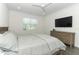 Cozy bedroom featuring a large window, a ceiling fan, and a dresser for storage at 4548 Dulwik Pl, Sanford, FL 32771
