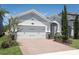 Charming single-Gathering home with a manicured lawn and brick driveway leading to a spacious two-car garage at 4548 Dulwik Pl, Sanford, FL 32771