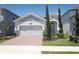 Inviting single-story home with a well-maintained lawn and a brick-paved driveway leading to an attached two-car garage at 4548 Dulwik Pl, Sanford, FL 32771