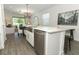 Well-lit kitchen featuring a stainless steel sink, white cabinetry, quartz countertops, and seamless access to the living area at 4548 Dulwik Pl, Sanford, FL 32771