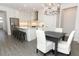 Open-concept kitchen featuring white cabinets, a large island with seating, and stainless steel appliances, seamlessly connects to dining area at 4548 Dulwik Pl, Sanford, FL 32771