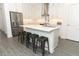 Modern kitchen featuring white cabinetry, stainless steel appliances, a spacious center island with seating, and stylish gray flooring at 4548 Dulwik Pl, Sanford, FL 32771