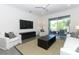 Bright living room with large TV, cozy seating, and sliding glass doors to an outdoor patio at 4548 Dulwik Pl, Sanford, FL 32771