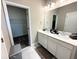 Modern bathroom featuring double sinks, white cabinets, and a view into the walk-in closet at 4828 Abbeywood Aly, Winter Garden, FL 34787