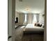 Bright bedroom featuring plush carpet, a large bed, and soft, natural light from two windows at 4828 Abbeywood Aly, Winter Garden, FL 34787