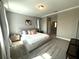 Spacious bedroom boasts a large platform bed, soft carpet, and a view of an adjoining room at 4828 Abbeywood Aly, Winter Garden, FL 34787
