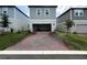 A brick driveway leads to a two-car garage of a modern home at 4828 Abbeywood Aly, Winter Garden, FL 34787