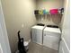 This laundry room features a washer and dryer with shelving for storage at 4828 Abbeywood Aly, Winter Garden, FL 34787