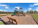 Community playground featuring slides, climbing structures, and benches on a wood chip surface at 4828 Abbeywood Aly, Winter Garden, FL 34787