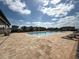 Community pool boasts ample lounge chairs and a beautiful view of neighborhood homes on a sunny day at 4828 Abbeywood Aly, Winter Garden, FL 34787