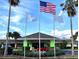 Attractive building with vibrant green trim, complemented by the American flag and mature landscaping at 5245 W Irlo Bronson Memorial Hwy # 170, Kissimmee, FL 34746