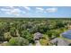 Expansive aerial perspective of homes among verdant trees, showing neighborhood layout and proximity to a lake at 5494 Glen Oak Pl, Sanford, FL 32771