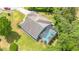 An aerial view shows a lovely house with a screened-in pool and a well-maintained lawn surrounded by mature trees at 5494 Glen Oak Pl, Sanford, FL 32771