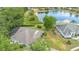 Aerial view of a home next to a lake, featuring a screened-in pool, mature trees, and beautiful landscaping at 5494 Glen Oak Pl, Sanford, FL 32771
