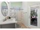 Well-lit bathroom with walk-in shower and a view of the backyard at 5494 Glen Oak Pl, Sanford, FL 32771
