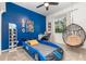 Fun bedroom with bright blue accent wall, race car bed and hanging chair at 5494 Glen Oak Pl, Sanford, FL 32771