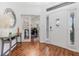 Inviting home foyer features sleek wood floors, a decorative console table, and a modern glass front door at 5494 Glen Oak Pl, Sanford, FL 32771