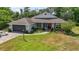 Charming single-story home with a manicured lawn, attached garage, and inviting front entrance with a red door at 5494 Glen Oak Pl, Sanford, FL 32771