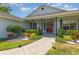 Inviting front porch with colorful flowers, attractive landscaping, and a striking red front door with wreath at 5494 Glen Oak Pl, Sanford, FL 32771
