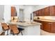 Modern kitchen with warm wood cabinets, stainless steel appliances, and granite countertops with seating at 5494 Glen Oak Pl, Sanford, FL 32771