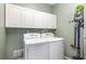 Functional laundry room featuring a washer, dryer, and overhead storage cabinets at 5494 Glen Oak Pl, Sanford, FL 32771