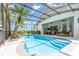 Resort-style screened-in pool area with a custom design, complemented by lounge seating and a lush tropical palm at 5494 Glen Oak Pl, Sanford, FL 32771